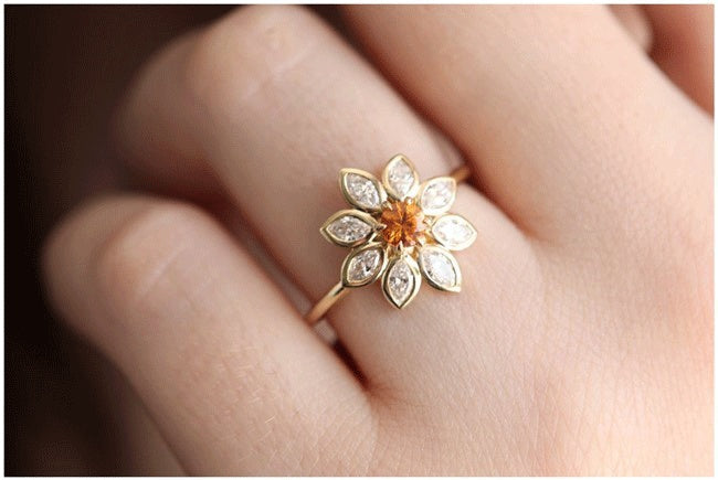 Velora diamond studded sunflower ring with gold band worn on finger