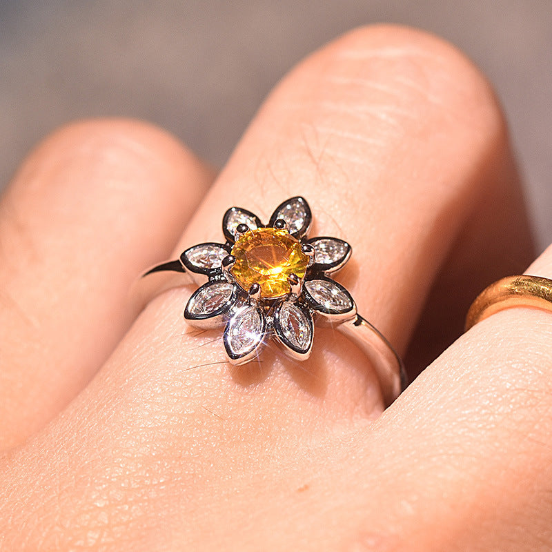 Velora diamond studded sunflower ring with yellow center stone on finger close-up
