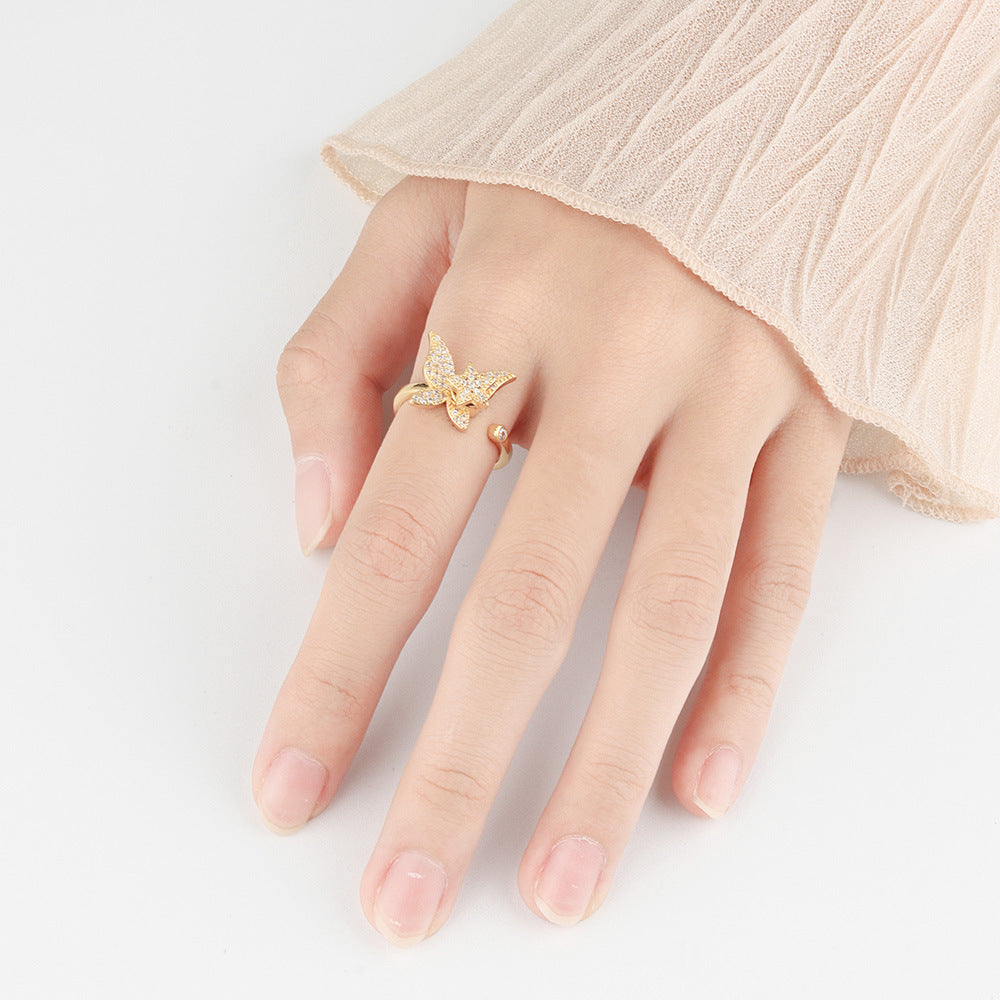 Velora Ring unique spinning butterfly ring gift in gold worn on hand with beige sleeve