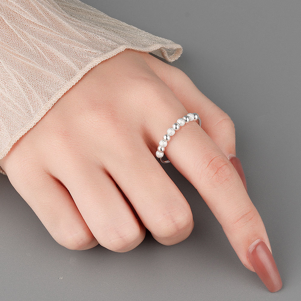 Velora Ring worn on finger featuring a stylish frosted rotation ring design with silver bead texture
