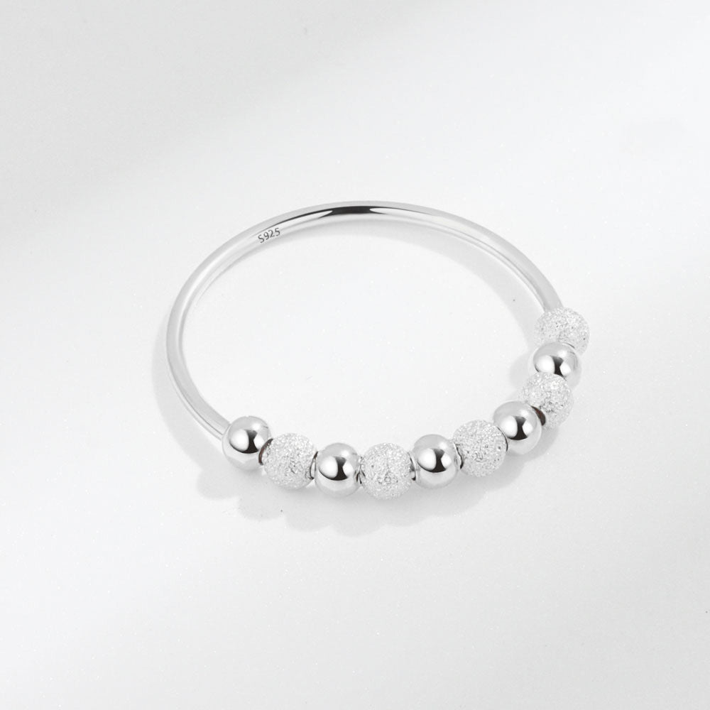 Velora Ring featuring a frosted rotation ring design with polished and textured silver beads