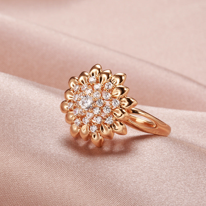 Velora women's floral cocktail ring with gold petals and sparkling clear stones on soft pink fabric